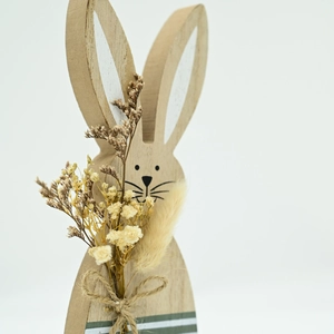 Detail of Easter wooden bunny with natural grain and dried flower bouquet decor