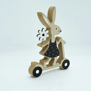 Detail of wooden Easter bunny on scooter with polka dot dress and white flower
