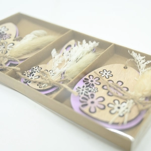 Close-up of Easter wooden bunny and egg ornaments with lavender accents in a gift box