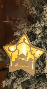 Stella in legno LED per Ramadan con intaglio di moschea appesa a un ramo di pino