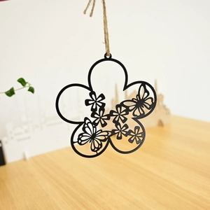Detail of vintage black metal flower wreath with laser-cut butterfly and rustic jute rope