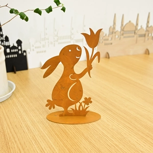 Rustic metal Easter bunny garden statue holding a tulip with a weathered rust finish