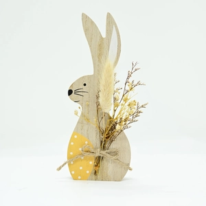 Close-up of wooden Easter bunny figurine with rustic twine and dried flowers detail