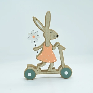 Detail of wooden Easter bunny on a scooter with pink polka dot dress and wood grain