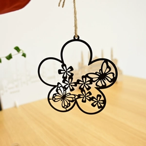 Detail of laser-cut metal floral wreath pendant with butterfly and rustic hemp rope