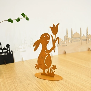 Detail of rusty metal Easter bunny figurine with tulip on a rustic wooden surface
