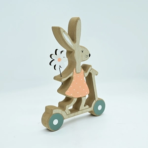 Close-up of wooden Easter bunny on a green scooter wearing a pink polka dot dress