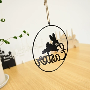Detail of black Easter metal wreath hanging decoration with rabbit and rope