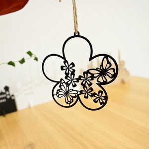 Detail of laser-cut metal wreath with butterfly and floral patterns on natural jute rope