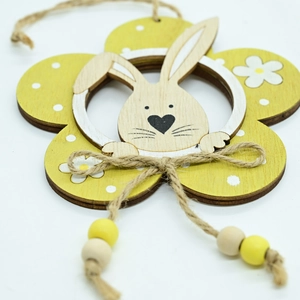 Detail of wooden Easter flower pendant with bunny head and white polka dots on yellow petals