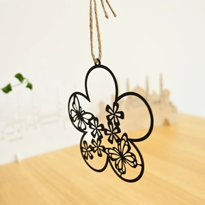 Detail of black metal flower wreath with butterfly cutout design and rustic jute rope