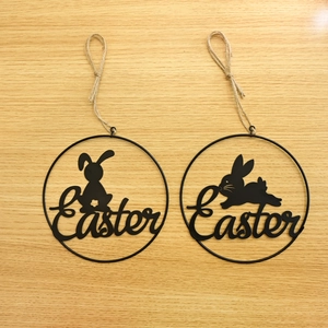 Close-up of black metal Easter wreath hangers with rabbit silhouettes and jute rope