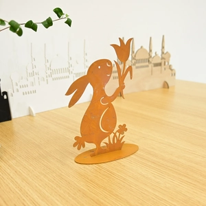 Detail of rusty metal Easter bunny ornament with tulip on stable wooden base