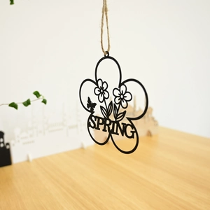 Close-up of black metal floral wreath with bird butterfly and Spring text detail