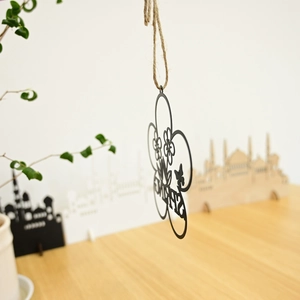 Detail of black laser-cut metal SPRING hanging decoration with rustic twine rope