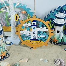 Detail of nautical wooden ornament featuring a lighthouse and anchor on beach sand