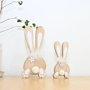 Detail of two wooden bunny ornaments with white fur pom-poms for Easter decoration