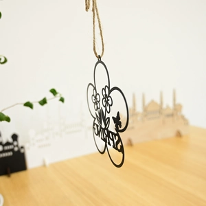 Close-up of black metal laser-cut SPRING wreath hanger with flowers and butterfly