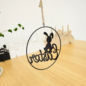 Detail of metal Easter wreath hanging ornament with black rabbit silhouette and text