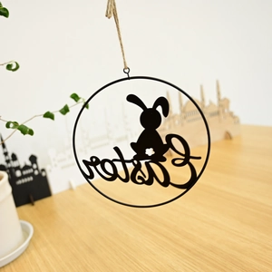 Detail of metal Easter bird wreath hanging with a rabbit silhouette and text
