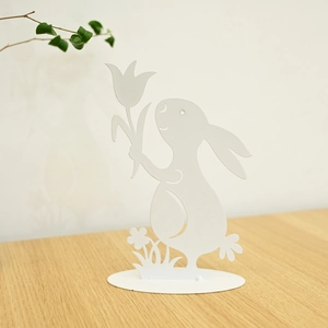 Detailed view of white metal Easter bunny silhouette with tulip on stable oval base