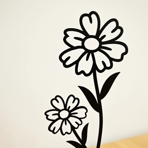 Detailed view of black metal flower wall art sculpture with minimalist floral design