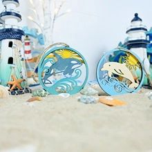Detail of laser-cut wooden nautical ornaments featuring orca and dolphin sea life designs