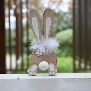 Detail of wooden Easter bunny with fluffy feather collar and tail on a natural background