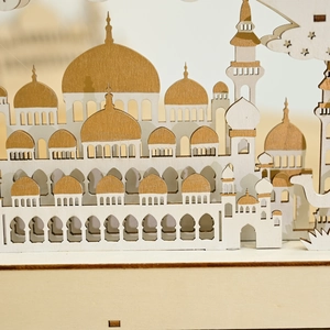 Dettaglio della lampada lunare in legno tagliata al laser con architettura di moschea