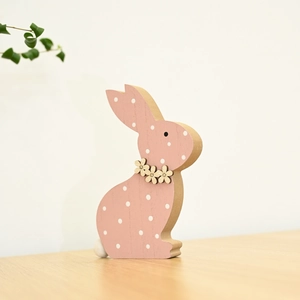 Nahaufnahme von rosa Osterhase aus Holz mit weißen Punkten und floralen Details
