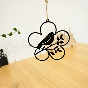 Close-up of a black metal bird and wreath hanging decoration with rustic jute rope detail