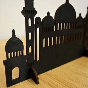 Macro view of black laser-cut wooden Eid Islamic mosque silhouette ornament on table