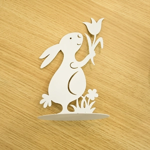 White metal Easter bunny figurine with tulip flowers on wooden surface detail