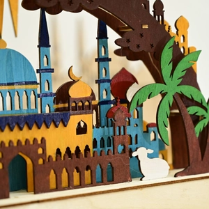 Detailed close-up of multilayered wooden Eid moon lamp with colorful mosque carvings