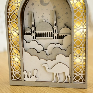 Close-up of laser-cut wooden Eid lantern with mosque motif and warm LED lighting