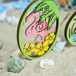 Detail of wooden flamingo hanging sign with palm leaves on a sunny beach background