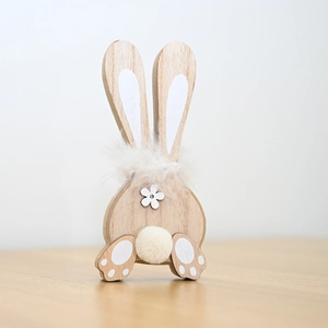 Macro shot of wooden bunny decor with plush tail and floral detail for Easter desktop display