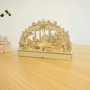 Macro detail of laser-cut wooden moon lamp with silhouette of mosque and palm trees