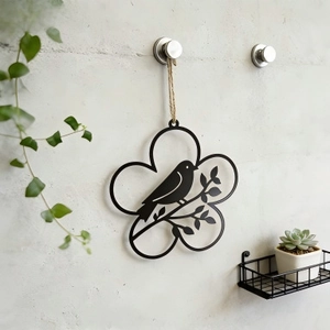 Minimalist black metal wreath wall decor with birds on branches in a home setting