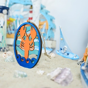 Detail of wooden ocean lobster ornament with laser-cut layers on beach decor