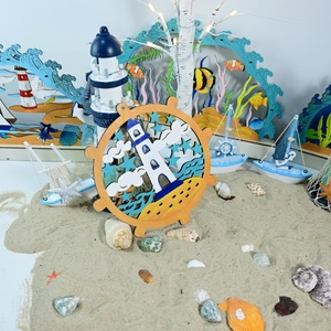Detail of wooden nautical wall plaque with lighthouse and anchor in beach scene setting