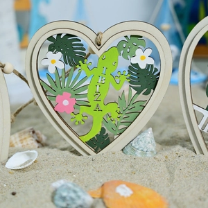 Mediterranean heart wooden pendant with green gecko and Ibiza text on a sandy beach