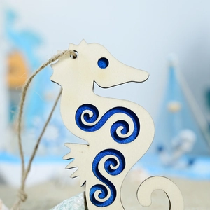 Macro view of seahorse wooden pendant with laser-cut swirl pattern and blue core
