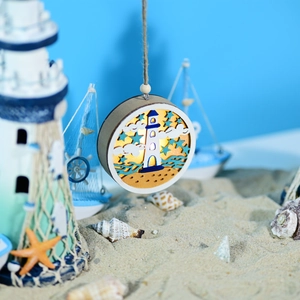 Detail of wooden ocean LED ball light with carved lighthouse and warm glowing effect