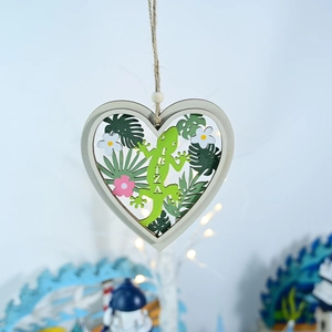 Detail of heart wooden ornament with green lizard, Ibiza text and tropical palm leaves