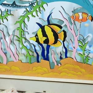 Dettaglio ravvicinato della decorazione marina 3D in legno con pesci tropicali colorati
