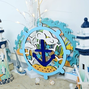 Detail view of a nautical wooden steering wheel ornament with anchor on a sandy beach