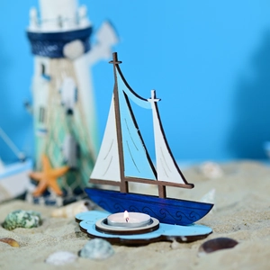 Détail du bougeoir voilier en bois méditerranéen avec décor de coquillages sur sable