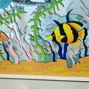 Dettaglio macro della lampada 3D in legno oceano con pesci tropicali e coralli laser