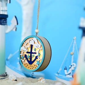 Macro view of nautical LED wooden ball light with layered anchor and sailboat design